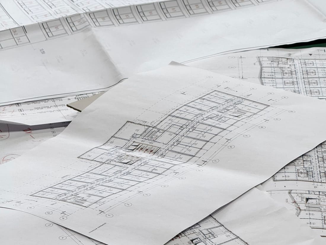 Plans d’architecte et calques techniques étalés sur une table