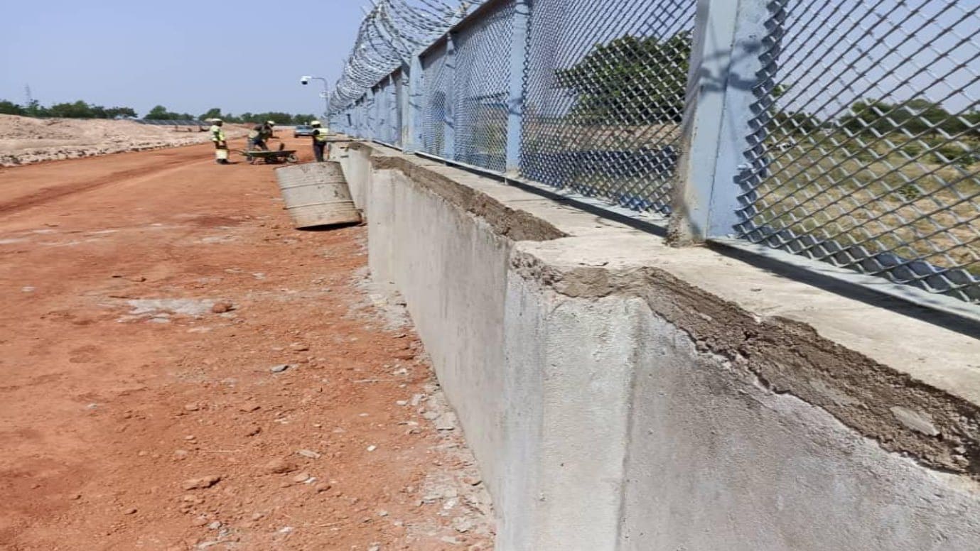 Mur de clôture périmétrique surmonté d'un grillage de protection