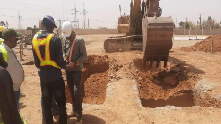 Travaux de terrassement à la pelle hydraulique, équipes en équipement de protection
